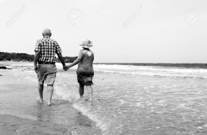 20667296-happy-senior-couple-walking-together-on-a-beach-couple-elderly-old